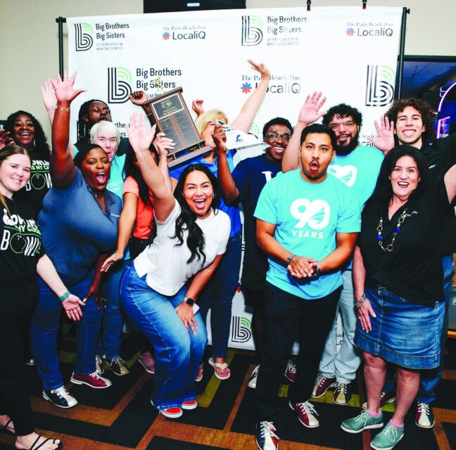 Seacoast Bank team cheering with raised hands and a Best Team Spirit trophy at Greenacres Bowl