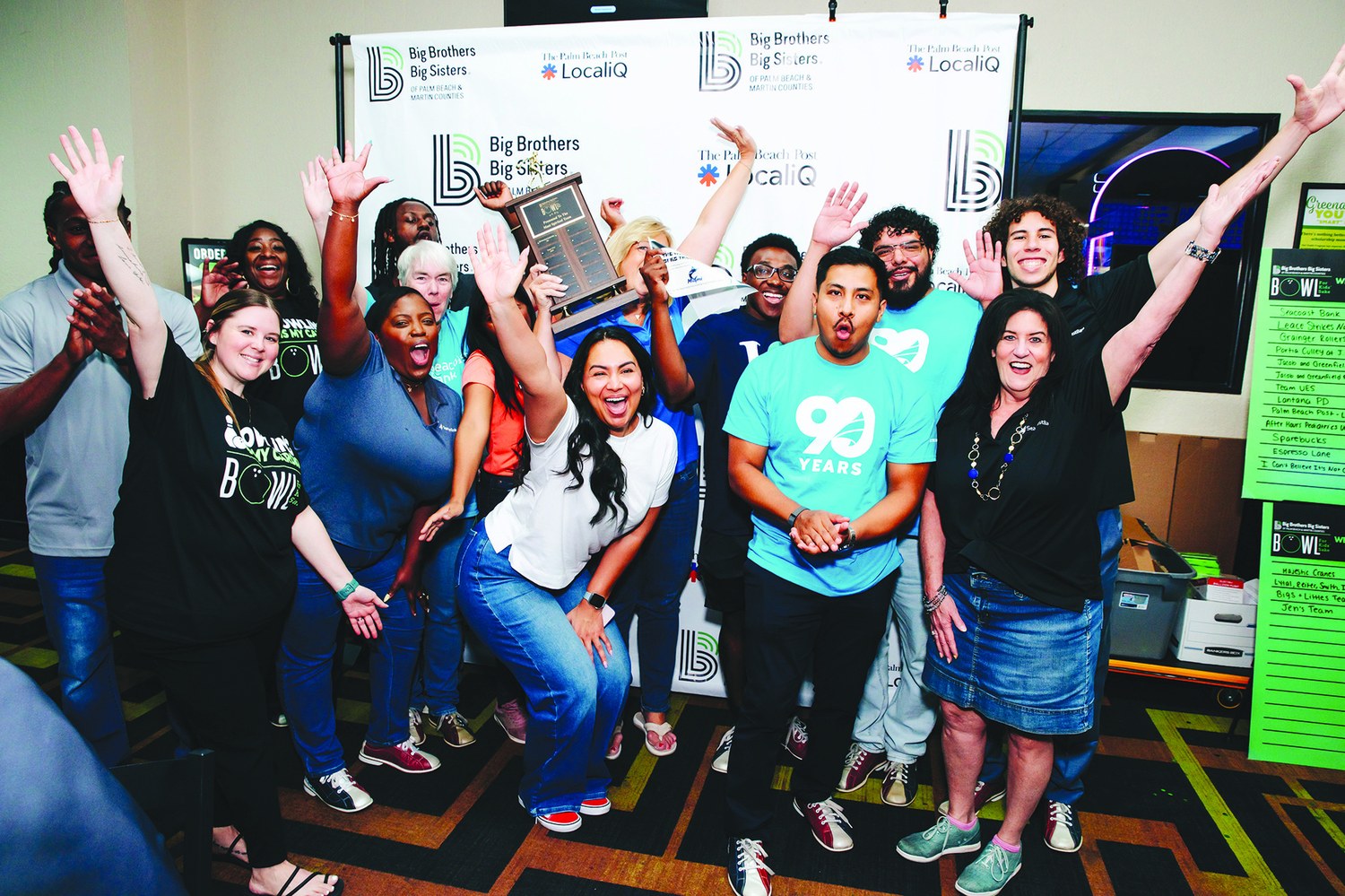 Seacoast Bank team cheering with raised hands and a Best Team Spirit trophy at Greenacres Bowl