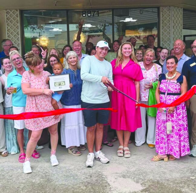 Chamber members cutting a red ribbon at Hobe Sound Beach Shop's new location