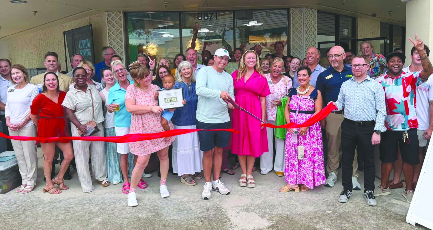 Chamber members cutting a red ribbon at Hobe Sound Beach Shop's new location